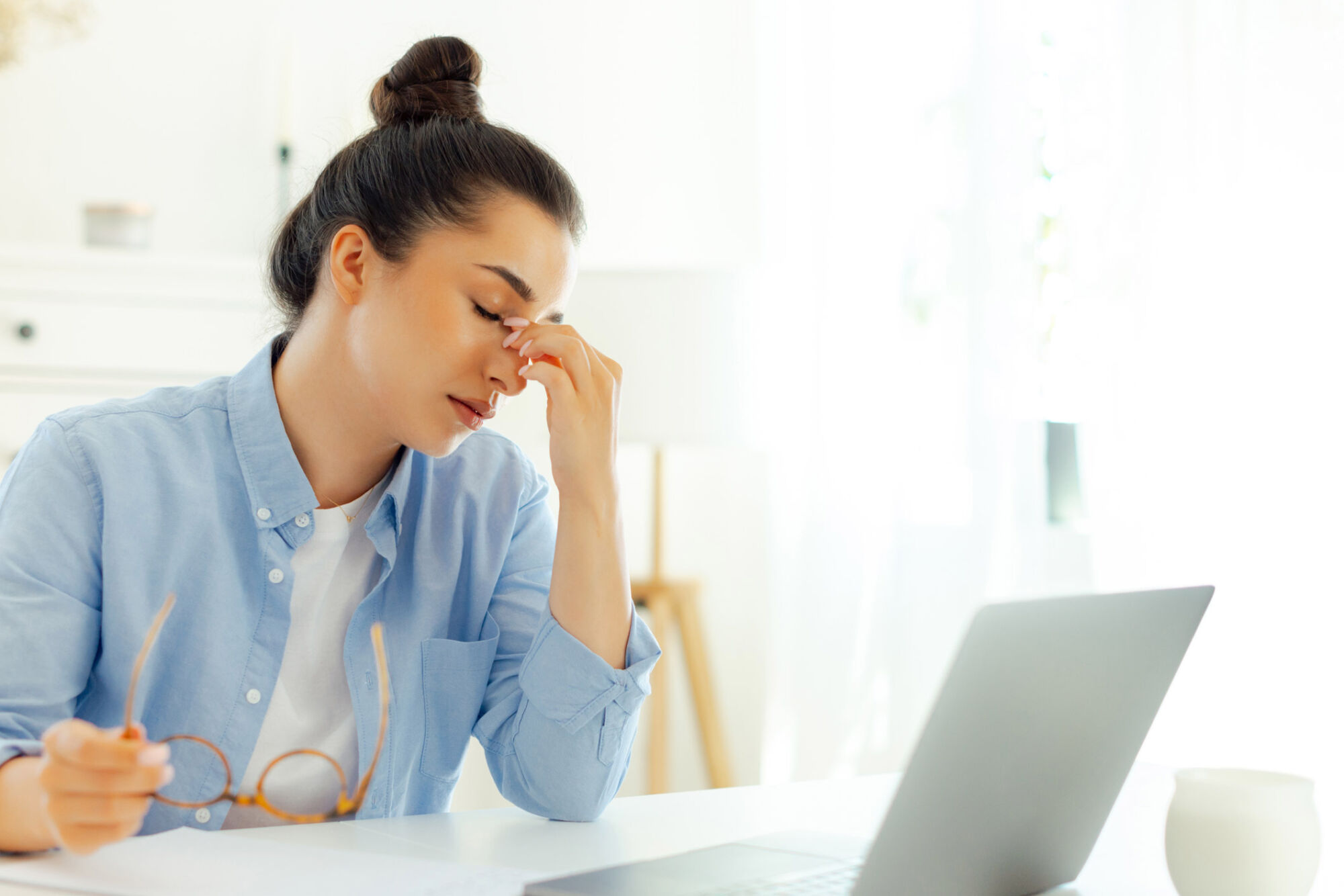Fatigued woman suffering eyestrain in a coffee shop