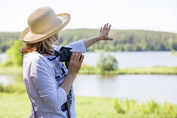 elderly-woman-with-a-camera-standard-cataract-surgery Elderly womand enjoying clear vision in nature after standard cataract surgery