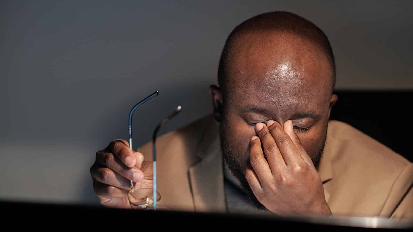 a man rubbing his eyes with signs of dry eye syndrome